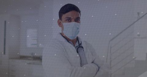 Confident male doctor in protective mask in modern hospital