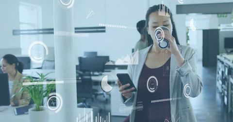 Businesswoman sipping coffee and checking phone with analytics hud in modern open office