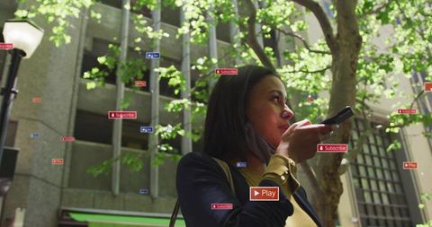 Urban commuter speaking into smartphone on sunny tree-lined street with ar icons