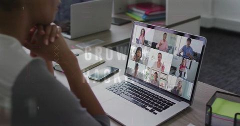 Asian woman joining virtual meeting on laptop in modern office workspace