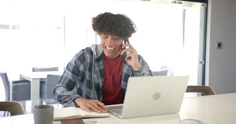Happy Young Man Multitasking in Home Office Kitchen