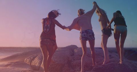 Friends Enjoying Sunset by Rocky Beach