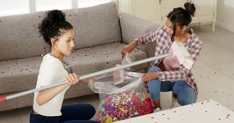 African American Women Clean Confetti After Celebration