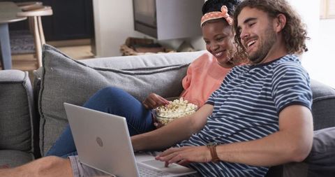 Diverse Couple Streaming Movie at Home with Popcorn
