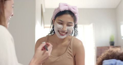 Diverse Friends Enjoying Relaxation with Facial Masks in Bedroom