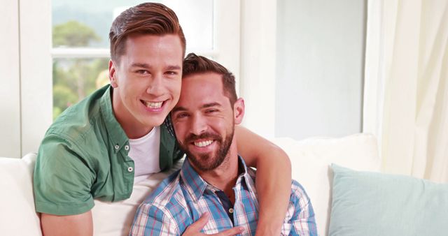 Two young Caucasian men share a joyful moment together, with copy space. Their smiles and close embrace suggest a strong bond and happiness in each other's company.