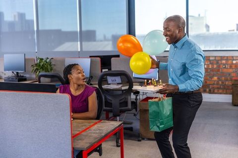 Colleagues celebrating birthday in modern open office