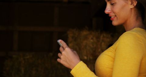 Smiling woman engaging with smartphone in rural environment