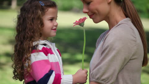 Mother and Daughter Bonding with Flower in Park
