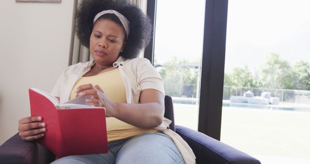 Young African American Woman Reading Book by Window - Download Free Stock Images Pikwizard.com