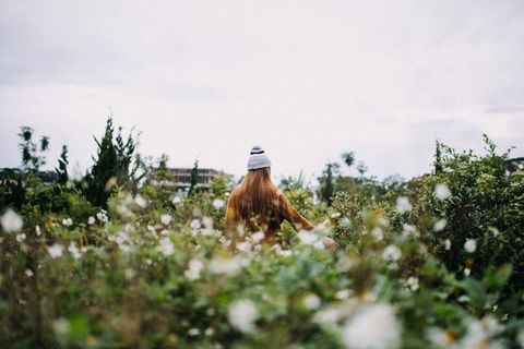 Young Woman Enjoying Nature Amidst Wildflowers