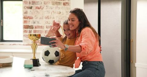 Mother and Daughter Celebrating Football Victory in Kitchen
