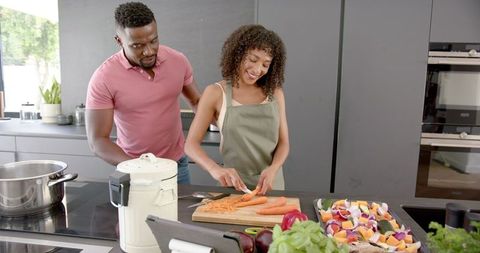 Happy Couple Cooking Together with Fresh Vegetables at Home