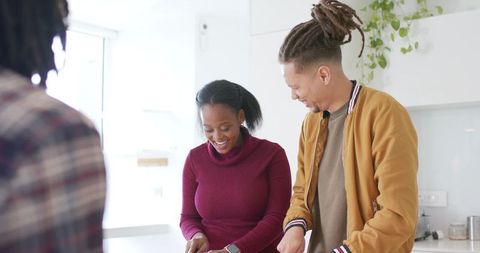 Sunlit modern kitchen with diverse couple chopping vegetables, smiling during meal prep