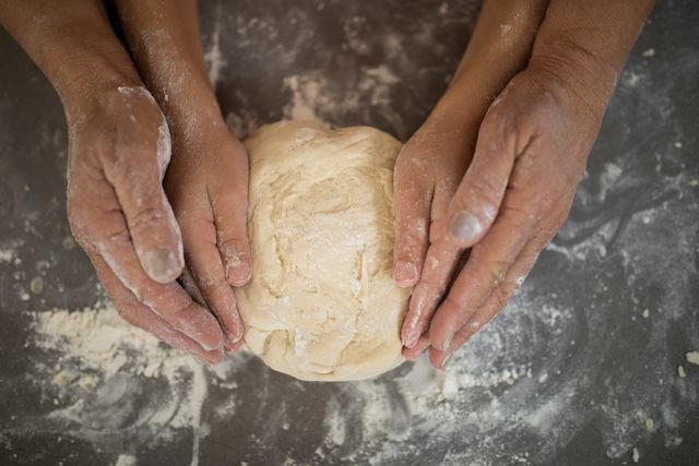 Close- up of grandmother and granddaughter holding dough in their hand
