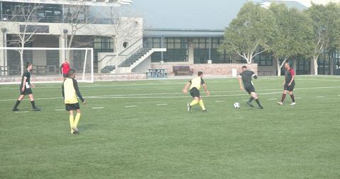 Youth soccer team achieving coordination on field in daytime match