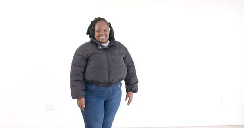 Confident woman wearing black jacket against white background