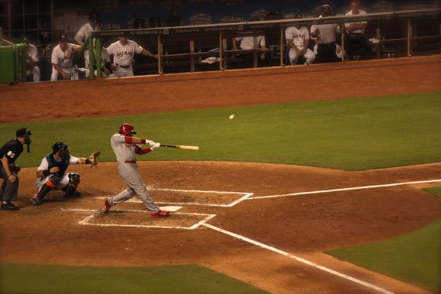 Scene shows a baseball batter hitting the ball during a game in a stadium. Ideal for use in sports articles, promotional materials for baseball events, adverts for sports equipment, or websites focused on sports and athlete stories.