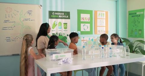 African american teacher guiding diverse elementary students in hands-on recycling lesson