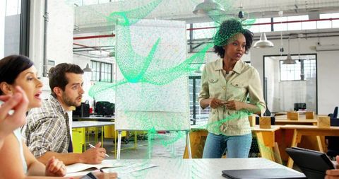 Leading creative team presenting strategy at flipchart in open-plan casual workspace