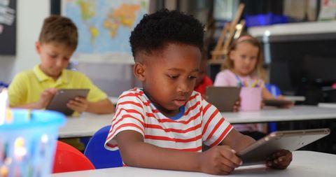Children engaged with technology in classroom environment
