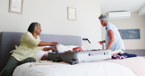 Senior Lesbian Couple Packing Suitcase for Vacation Together
