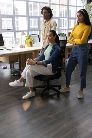 Diverse young professionals collaborating in bright modern office reviewing project at desk