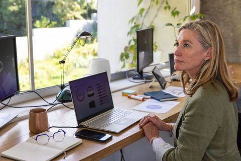Senior Woman Reviewing Charts in Bright Home Office