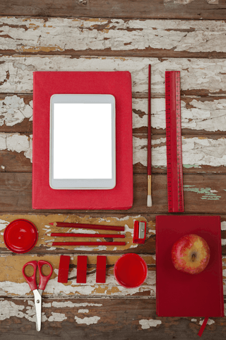 Transparent Digital Tablet with Red School Supplies on Rustic Table