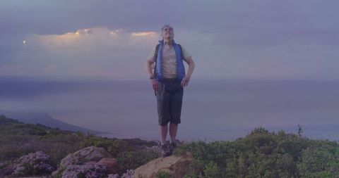 Hiker Enjoying Peaceful Ocean View from Rocky Hilltop