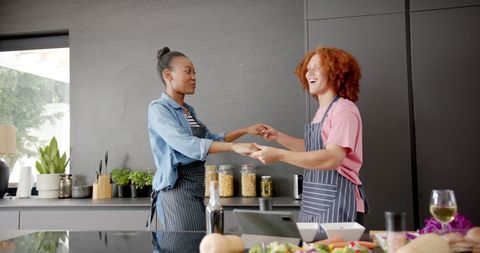 Joyful Couple Dancing While Cooking Together at Home