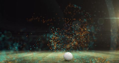 Colorful particles surrounding football on vibrant pitch