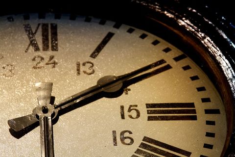 Close-up of antique clockface illuminated by dramatic lighting