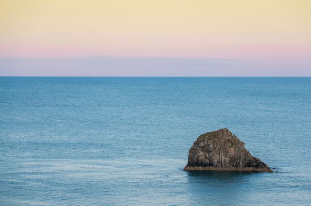 Solitary Rock in Tranquil Ocean at Dusk - Download Free Stock Photos Pikwizard.com
