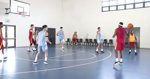 Intense Basketball Game with Diverse Athletes on Indoor Court