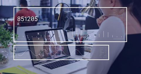 Remote Video Calling on Laptop with Data Overlays in Open-Plan Workspace