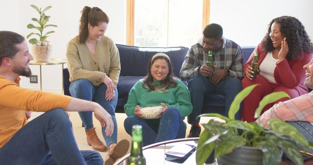 Diverse group of friends enjoying casual gathering at home, sitting on floor and couch, casually dressed. Excellent for representing friendship, leisure, relaxation, and social bonding in marketing materials, advertisements, or editorials.