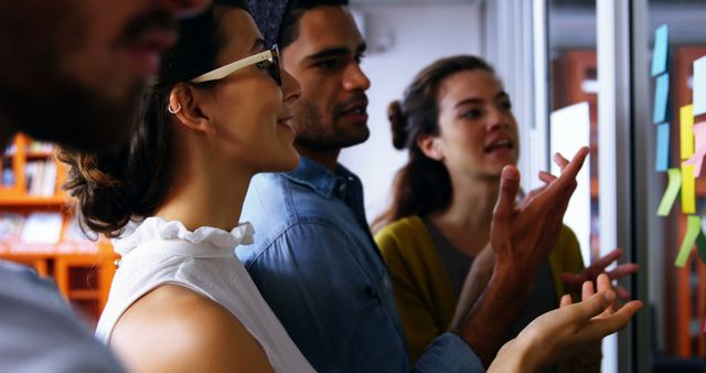 Young Professionals Discussing Ideas with Sticky Notes on Glass Wall - Download Free Stock Images Pikwizard.com