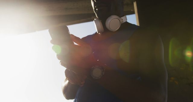 Athlete Using Smartphone and Headphones During Outdoor Workout - Download Free Stock Images Pikwizard.com