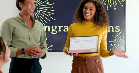 Diverse colleagues celebrating employee achievements in office environment