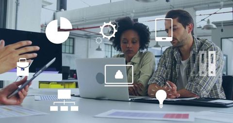 Professionals collaborating with digital technology in open workspace