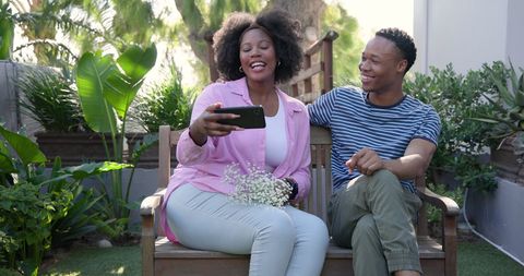 Smiling Couple Taking Selfie on Outdoor Bench