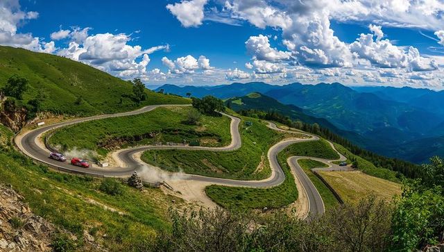 Mountain road racing with rally cars on hairpin turns