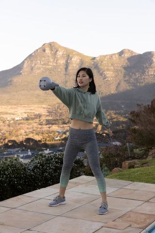 Woman Exercising with Kettlebell on Scenic Terrace
