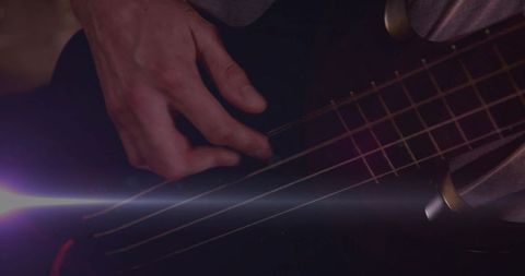 Close-Up Musicians Hand Playing Bass Guitar under Stage Lights