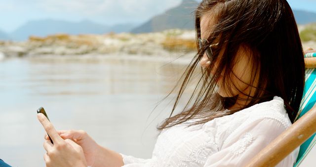 Young Woman Relaxing on Outdoor Chair Using Smartphone - Download Free Stock Images Pikwizard.com