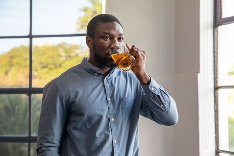 Man in modern lounge enjoying refreshing beverage near window
