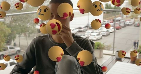 Man surrounded by virtual emoticons throughl contemplation
