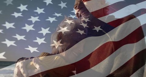 Senior couple embracing on beach with usa flag overlay