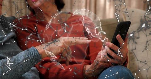 Senior couple exploring global connectivity on smartphone with digital network overlay